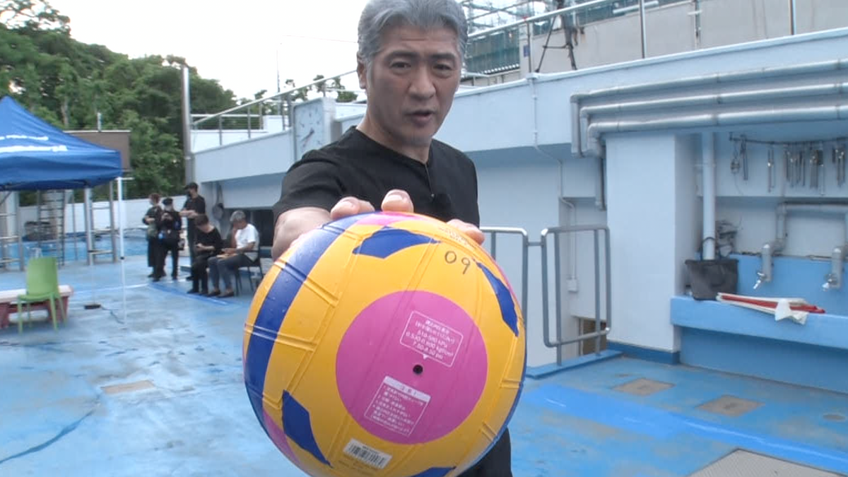 水球ボールを鷲掴(わしづか)みにして持つ吉川晃司さん