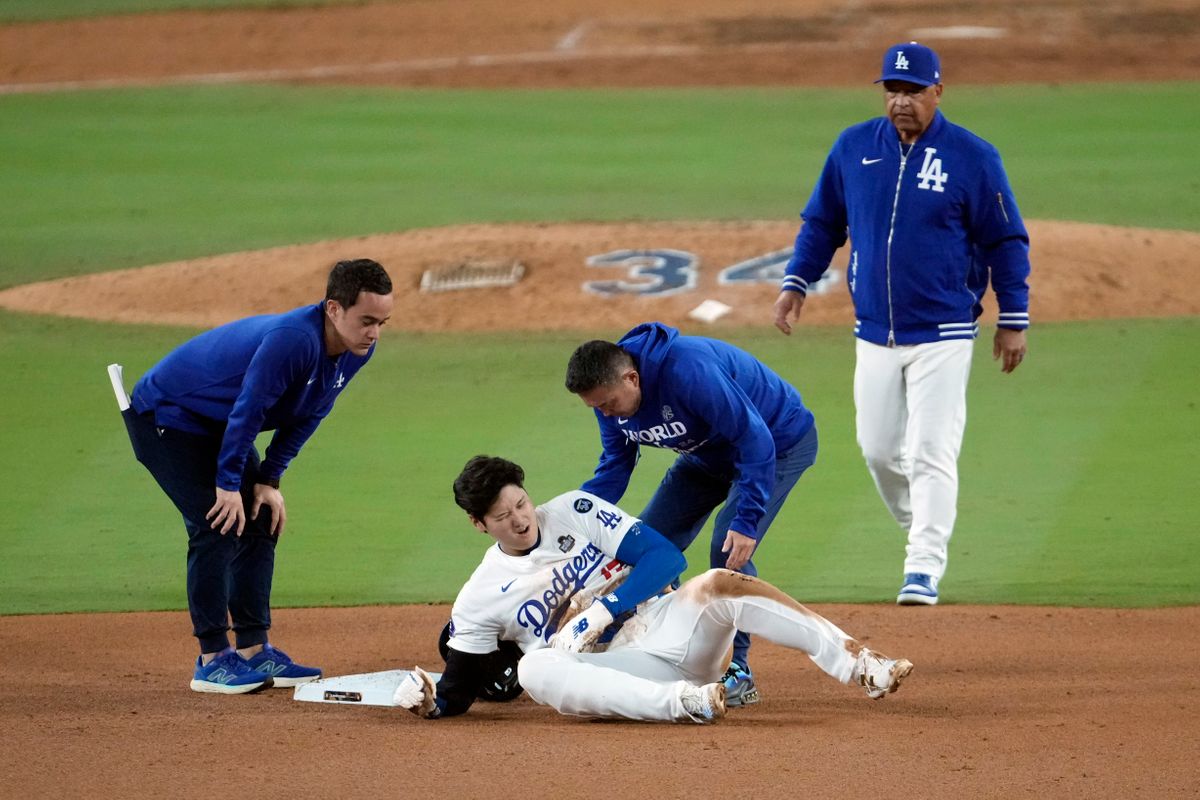 大谷翔平選手のケガに駆けつけるロバーツ監督(写真：AP/アフロ)