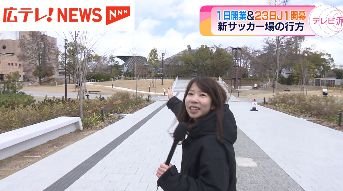 広島テレビの小田成実記者が指す方向に、サッカースタジアムの屋根が見える