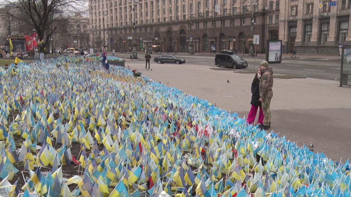 戦死した軍人らを悼むウクライナ国旗を見るオレクサンドルさんとマリヤさん（2024年2月16日　ウクライナ・キーウ）