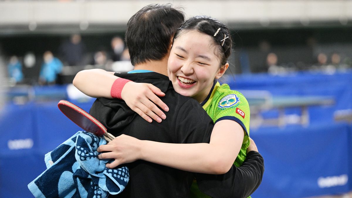 勝利しコーチである父親と抱き合って喜ぶ張本美和選手(写真：松尾/アフロスポーツ)