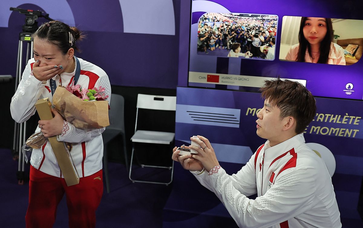 混合ダブルスで優勝した中国の黄雅瓊(左)に指輪を渡す中国代表の劉雨辰選手(写真：ロイター/アフロ)