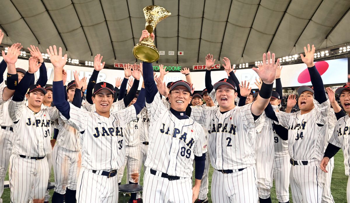 優勝トロフィーを掲げる侍ジャパン・井端弘和監督【中央】（写真：日刊スポーツ/アフロ）