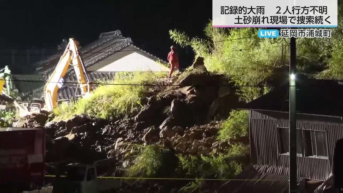 フェンスとコンクリートの壁ごと住宅に覆いかぶさる　日没後も捜索続く土砂崩れ現場