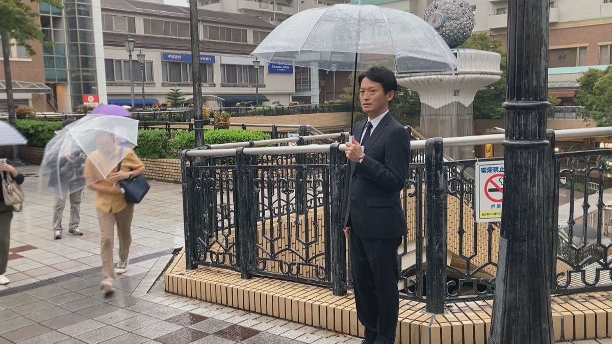 雨の中で街頭に立つ斎藤前知事