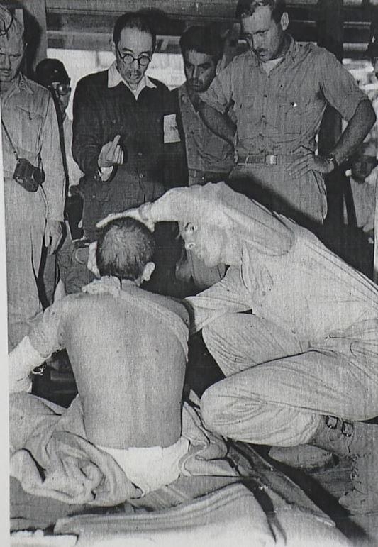 1945年9月、被爆者の診察を見守るノーラン医師（立っている人たちの一番右）ら（ノーランJr.教授提供）