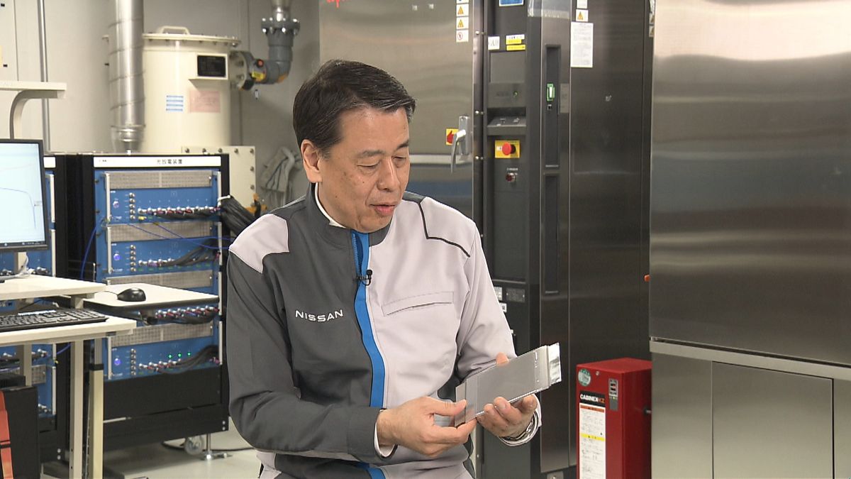 実験用の全固体電池のサンプルを持つ日産自動車の内田誠社長
