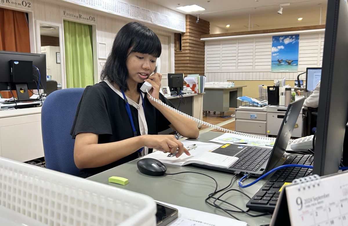 職場で電話に率先して出て日本語で応じるメリーさん（撮影・井上茂男）