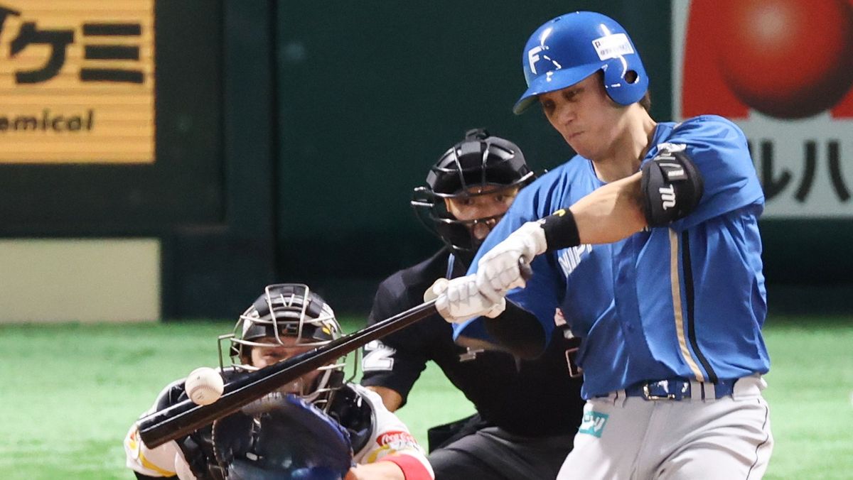 CSファイナルステージでHRを放つ日本ハムの伏見寅威選手(写真：時事)