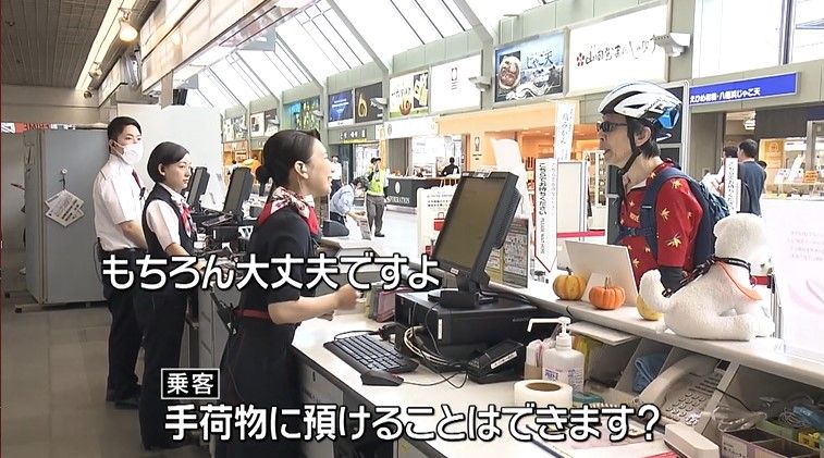 羽田行きカウンターで利用客の対応をする江川さん